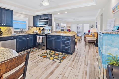 Enjoy cooking in this stylish beach condo kitchen featuring granite counters, modern appliances, and an open layout that flows into the living area—perfect for relaxing after a day by the ocean.