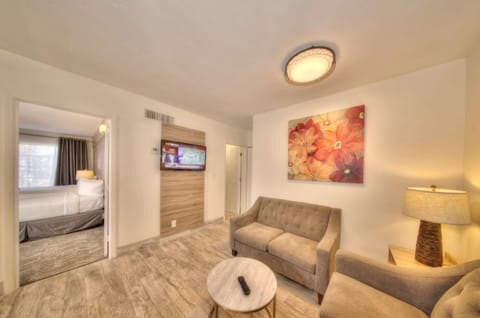 Living room with sofa, chair, table, lamp, and wall art
