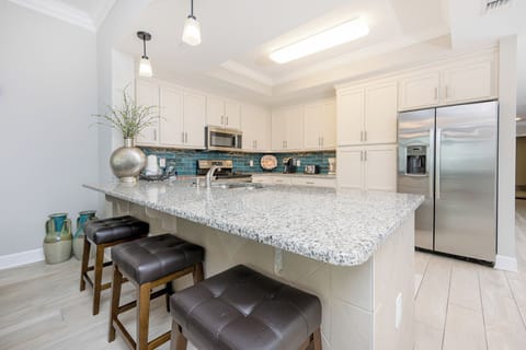 Sip your morning coffee at the breakfast bar and get ready for a beach day in this elegant space