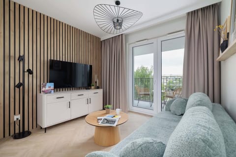 A spacious living room with a large, comfortable sofa, an elegant coffee table and a wall-mounted TV is the perfect place to relax.