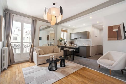 The living room features a sofa, HD flat-screen TV, and free high-speed Wi-Fi.
