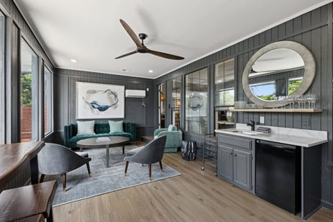 A stylish secondary lounge with moody tones, plush seating, and a fully stocked bar area for relaxing or entertaining.