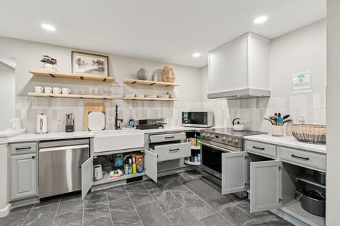 This stylish kitchen features open shelving, a deep farmhouse sink, and everything you need to cook at home.