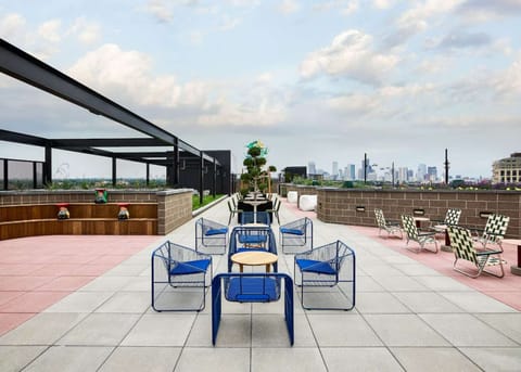 Rooftop terrace with colorful chairs and skyline in the distance