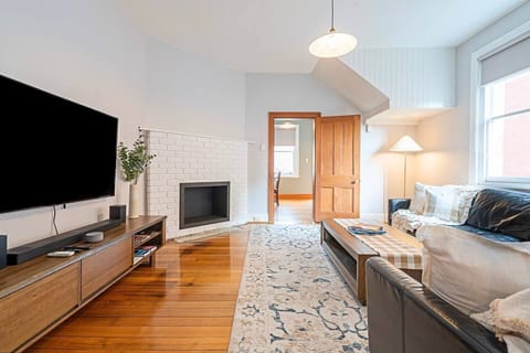 Unwind in the welcoming living room, where leather seating, a wall-mounted TV, and efficient split-system climate control create a relaxing space with year-round comfort.