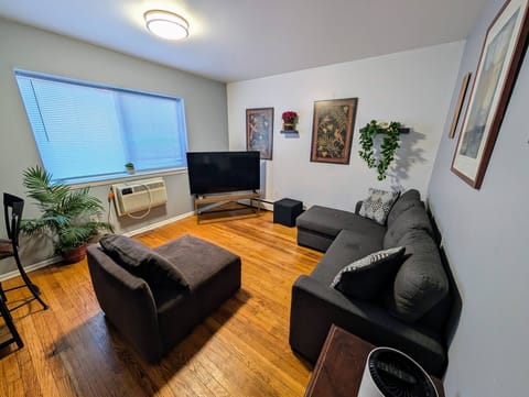 Living room with sectional couch, comfy chair and smart TV.