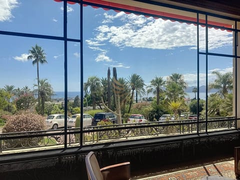 Vue mer et palmiers depuis les espaces communs de la résidence.
