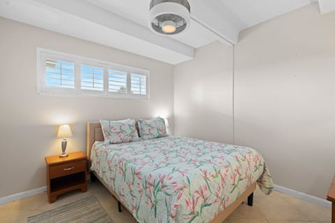 Rest easy in this inviting beach-style bedroom featuring tropical bedding and soft coastal tones—perfect for recharging after a sun-filled day by the ocean.