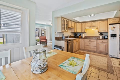 Enjoy beachside living in this airy kitchen and dining space, complete with coastal décor and modern appliances—perfect for relaxing meals after a sunny day by the shore.