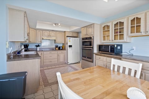 This fully equipped kitchen features modern appliances, ample counter space, and a cozy dining area—perfect for enjoying meals together during your beach vacation.