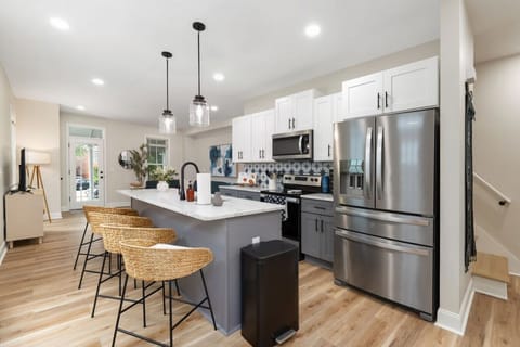 Modern kitchen with granite counters, stainless appliances, and large island seating.