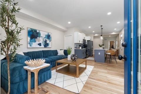 Bright open living space with high ceilings, sectional seating, and modern decor.