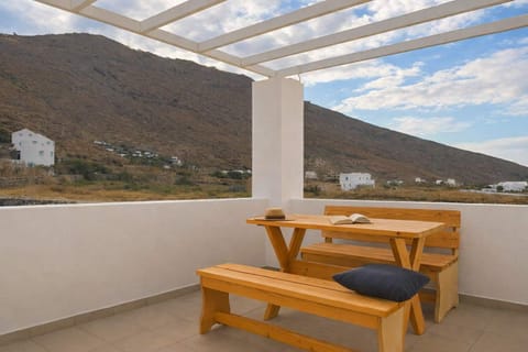 Outdoor Dining Terrace with Mountain Views
Wooden table and benches under a shaded pergola, ideal for outdoor meals and relaxation.