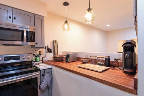 - Kitchen with wood countertop and pendant lights   - Stainless steel appliances and modern cookware   - Functional space for cooking during your stay