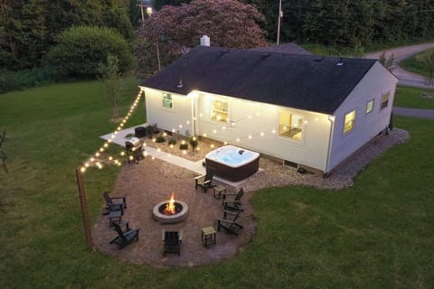 Experience the perfect backyard retreat with a private hot tub, glowing fire pit, and string lights that create a magical atmosphere for evenings under the stars with family and friends.