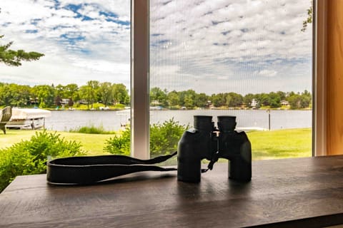 Wake up knowing the lake is right outside. Grab your coffee and watch the morning light hit the water from this living room — the binoculars are on the table for a reason.