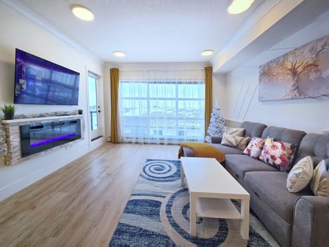 Spacious living room with fireplace, large windows, natural daylight