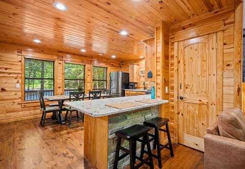 Kitchen island with granite top and bar seating, blending function and comfort in a wood-accented, open layout.