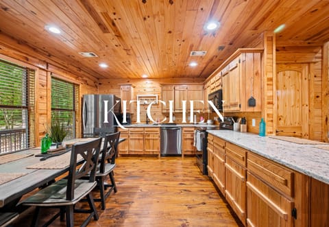 Rustic-style kitchen with granite countertops, full appliances, and a dining area for home-cooked meals with family or friends.