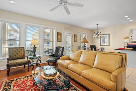Unwind in your elegant living space featuring plush leather seating, rich hardwood floors, and warm natural light flowing through oversized windows.