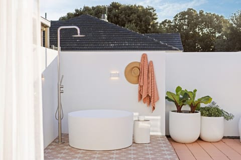 Unwind in the outdoor bath as warm light settles over the private courtyard.