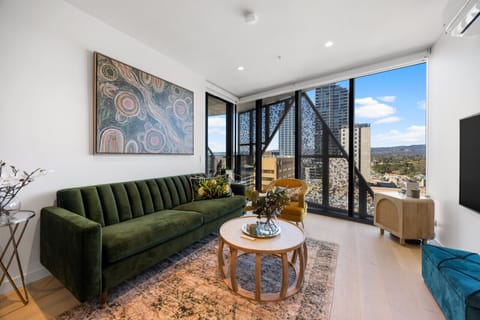 Unwind in the living area as natural light pours in and the city skyline sets the backdrop for a relaxed stay.