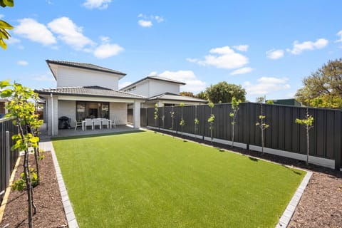 Gather around the outdoor dining table in the first house for relaxed BBQ dinners while the kids enjoy the spacious grassed backyard.