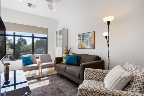 Unwind in the light-filled living area, where comfortable seating invites you to relax after a day out.