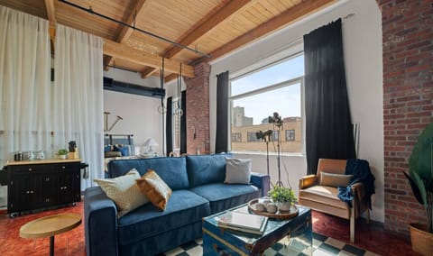 Cozy open-concept studio with stylish decor, exposed beams, and a sofa bed for extra guests.