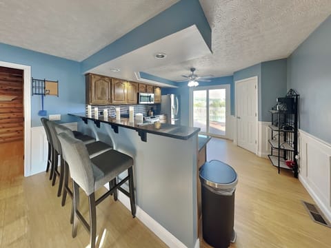 Fully Equipped Kitchen with Stainless Steel Appliances and Breakfast Bar Seating for Four