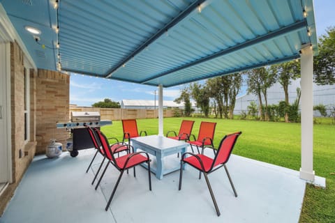 The covered patio featuring vibrant red sling chair and plenty of spce to gather