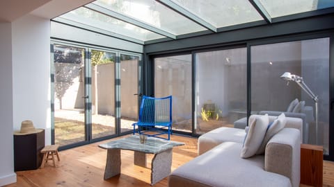 Relax in the bright sunroom with floor-to-ceiling glass and custom design touches.
#ModernDesign #NaturalLight #SunroomVibes #LovelyStay