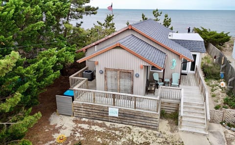 Aerial view of the cottage with the beach/bay in the backyard