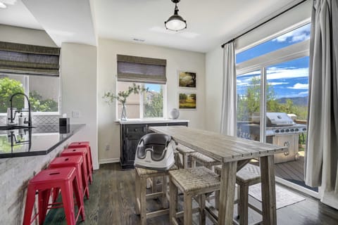 Charming and sunlit, this casual dining area features rustic seating, a view of the deck, and quick access to the grill—perfect for indoor-outdoor meals.

