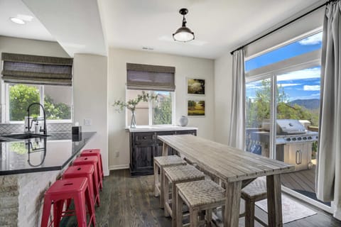 Gather around the rustic dining table or pull up a stool at the breakfast bar—this open-concept space connects seamlessly to the deck and grill.

