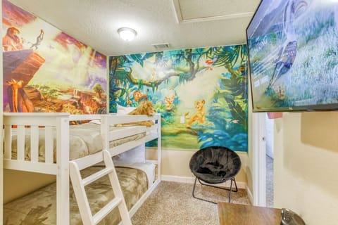Sleep surrounded by the magic of The Lion King, featuring an exclusive Thomas Kinkade art piece, cozy bunk beds, and a smart TV for family fun.