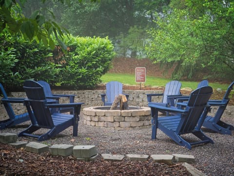 8 blue Adirondack chairs around the wood-burning fire pit — the heart of the compound, surrounded by rhododendrons.