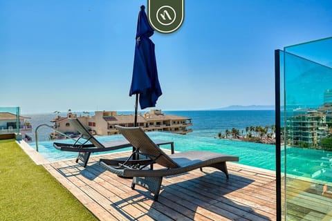 Step out onto the sun-drenched wooden deck and enjoy this stunning infinity pool. Equipped with comfortable lounge chairs and an umbrella, it offers breathtaking panoramic views of the ocean.