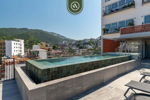 Relax in the elevated stone pool with views of the lush mountains and vibrant city. This rooftop oasis offers a perfect balance of modern luxury and scenic tranquility, ideal for soaking up the sun.