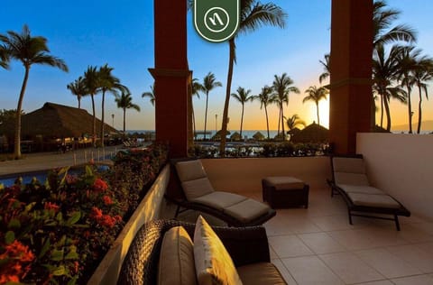 Unwind on your private terrace with comfortable lounge seating and beautiful sunset views over the resort grounds and ocean beyond.