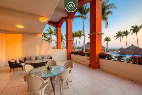 Relax on your private covered terrace featuring comfortable seating, outdoor dining, and beautiful views of the resort grounds and tropical surroundings.