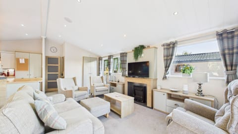 Comfy open-plan living room with TV and electric fire place.