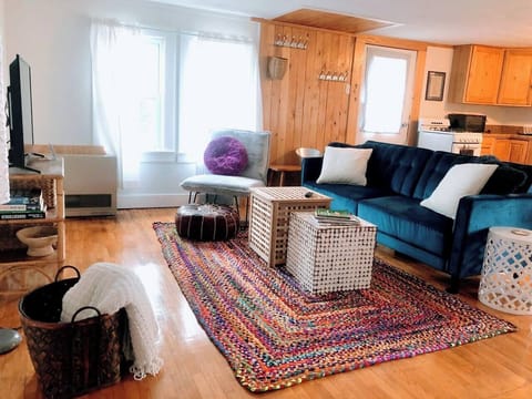 Living room open concept with kitchen and dining area. Couch converts to extra bed