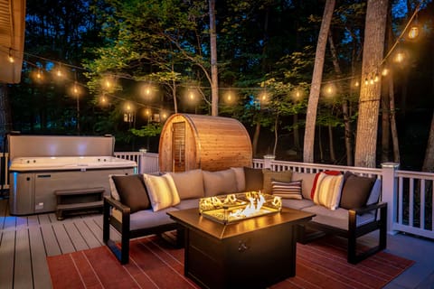 Unwind in comfort under twinkling string lights, enjoying the warm glow of the fire table, plush seating, private sauna, and soothing hot tub—all set within the peaceful privacy of the spacious rear deck.