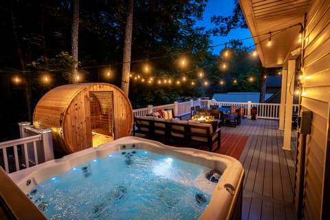 Relax on the rear deck with hot tub, sauna, fire pit, dining, Adirondacks, and games under the mountain trees.