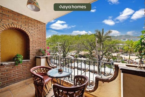 Cozy outdoor terrace featuring a wrought-iron railing, wooden table and chairs, and classic tiled flooring.