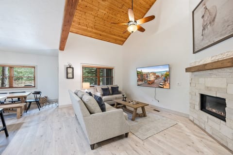 - Cozy living room with vaulted ceiling and wood accents for style  
- Flat screen TV and fireplace create the perfect entertainment space  
- Open floor plan connects living and dining for family gatherings