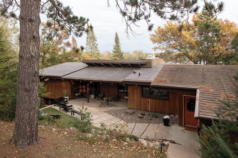 Mid-Century lines and a welcoming front patio with modern seating—your Northwoods retreat starts here.