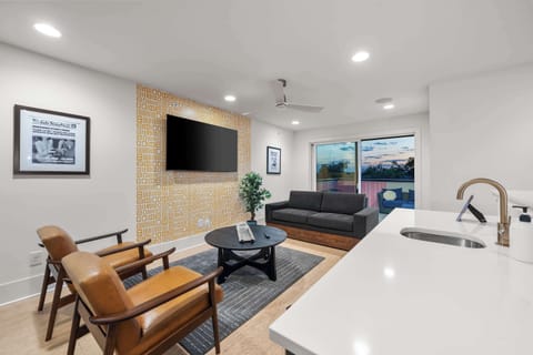 Cozy secondary social lounge area featuring mid-century modern leather armchairs.