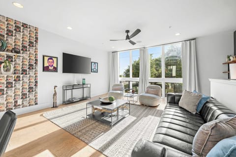 Expansive main living room featuring a long, luxury black leather sofa bed.